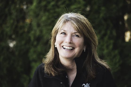 A member of the Sidewinder team outdoors, smiling, in a dark branded fleece.