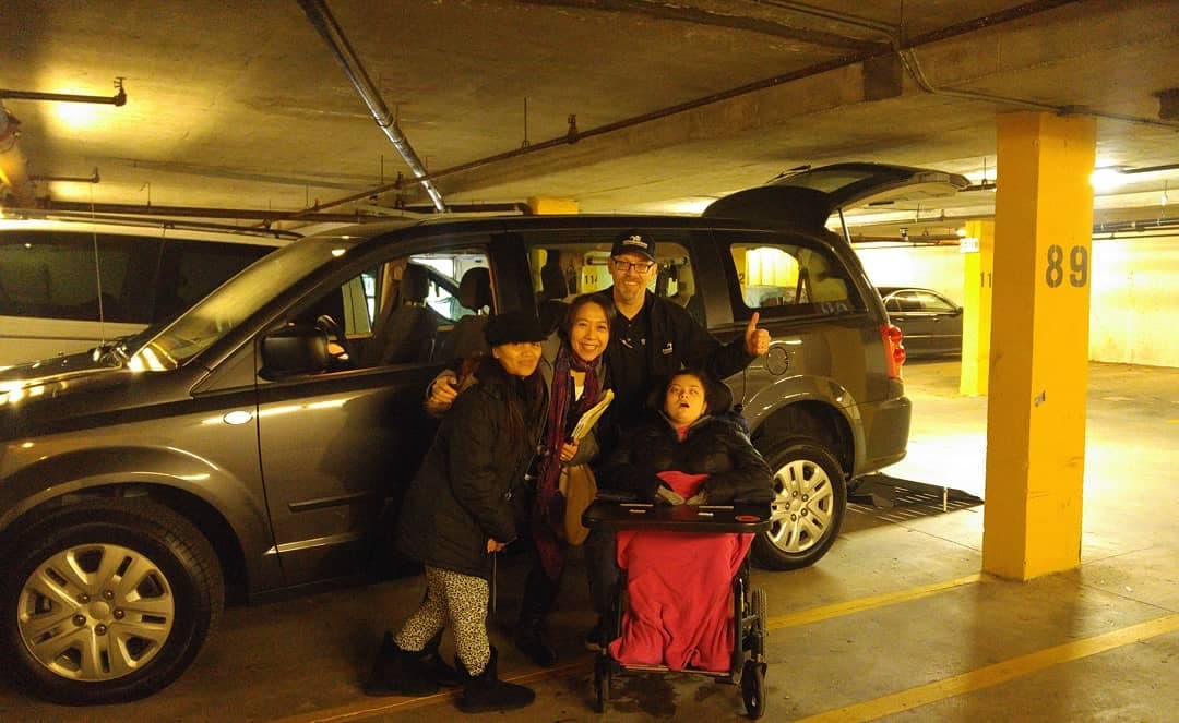 A family collecting a rear-entry accessible van from Sidewinder, ramp deployed