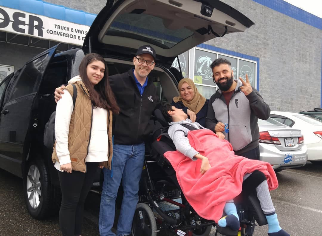 A family with their new accessible van on delivery day