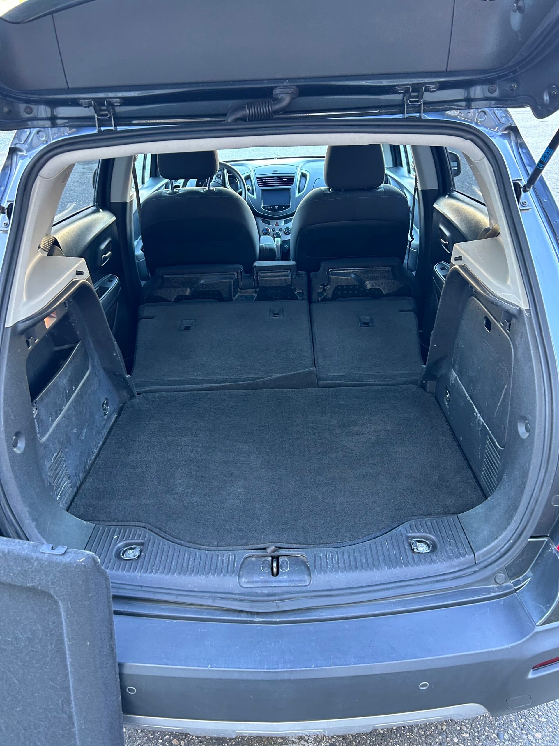 Cargo area of the Trax with the rear seats folded flat, opening up a long load floor toward the front seats