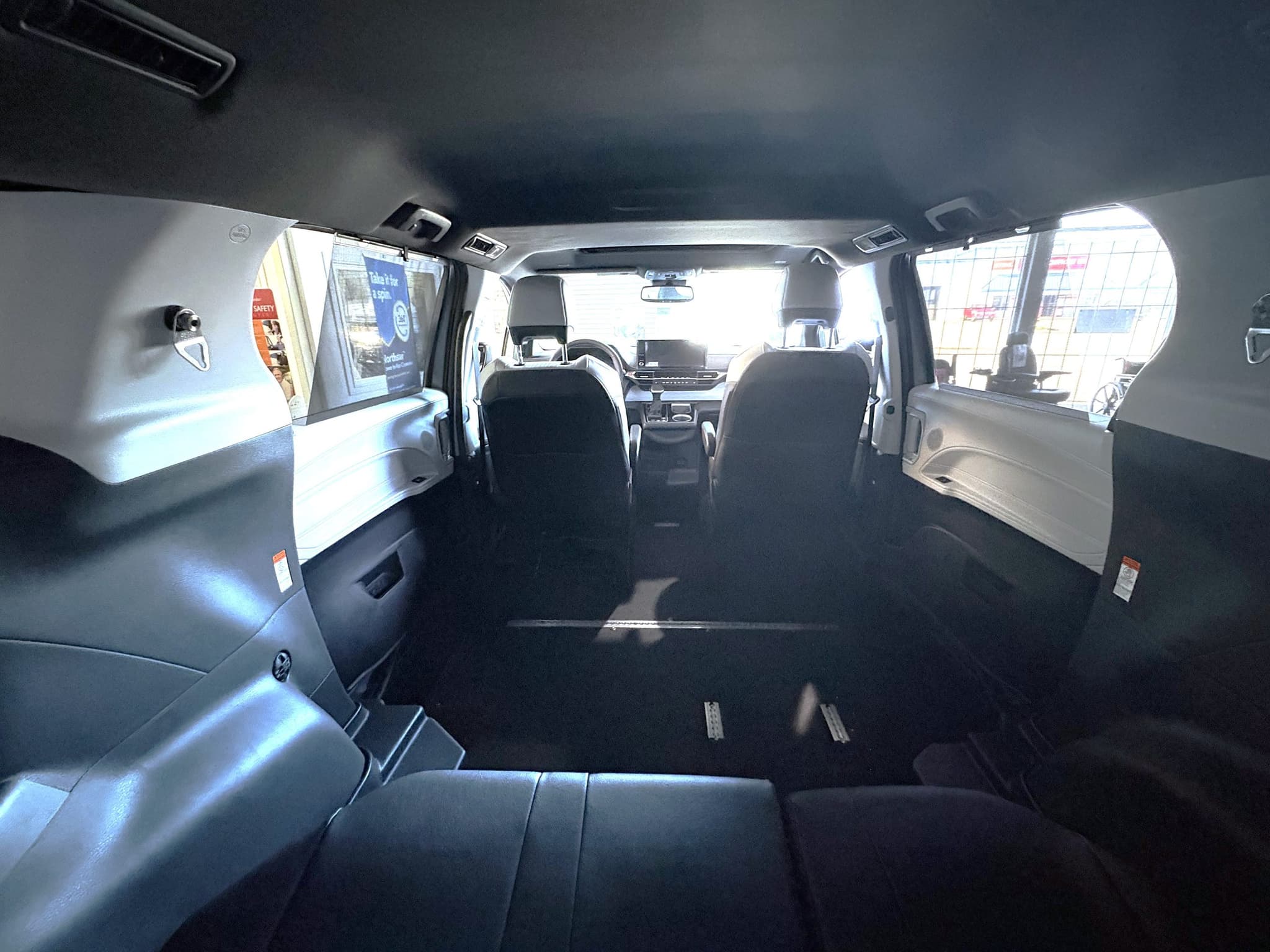 Interior of the Sienna from the rear looking forward, the second row removed to leave an open flat lowered floor with securement tracks running toward the front seats